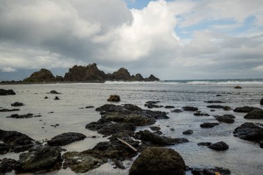 Filipinler, Baler 'deki göz kamaştırıcı Diguisit Sahili. Sergide kayalık oluşumlar ve sakin bir deniz manzarasıyla kaplı engebeli bir kıyı şeridi yer alıyor. Ön plandaki görüntüler, ikonik Diguisit kaya oluşumlarına yol açan yıpranmış kayaları çarpıcı bir şekilde karşı konuma getirdi. 