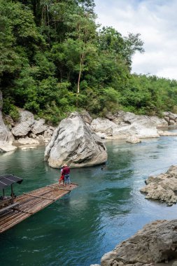 Turkuaz nehri, Minalungao Ulusal Parkı, Nueva Ecija, Filipinler 'deki yüksek kireçtaşı kayalıklarından ve yemyeşil alanlardan geçiyor..