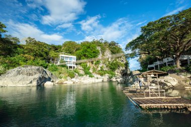 Turkuaz nehri, Minalungao Ulusal Parkı, Nueva Ecija, Filipinler 'deki yüksek kireçtaşı kayalıklarından ve yemyeşil alanlardan geçiyor..