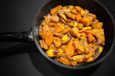 Lezzetli bir sosta pişirilmiş taze et, kızarmış muz ve havuçların yer aldığı Estofado yemeği..