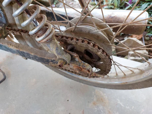 Paslı eski bir motosiklet zincirinin yakın çekimi.