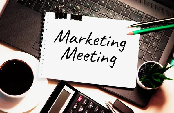 Marketing Meeting word is written on white piece of paper