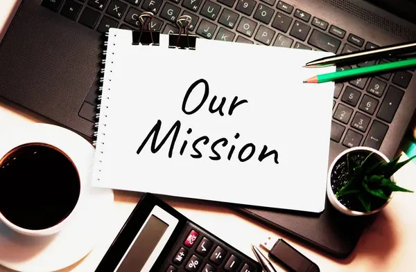 Our Mission is written on white piece of paper. Mission Aspiration Goals Ideas Inspiration Vision Concept