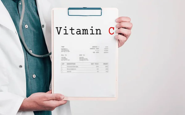 Doctor holding Paper Pad with Text Vitamin C