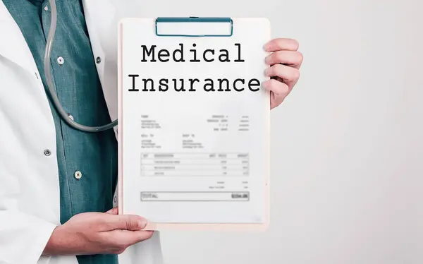 Doctor holding Paper Pad with Text Medical Insurance