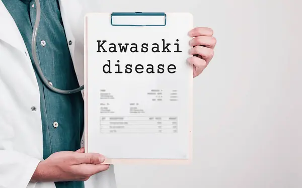 Doctor holding Paper Pad with Text Kawasaki disease