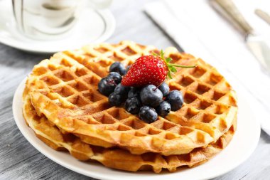 Ev mutfağında yapılan yaban mersinli ılık waffle kahvaltısı.