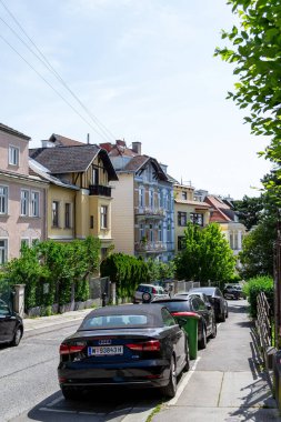 Viyana, Avusturya - 23.06.2023: Şehrin sakin bir bölgesinde küçük bir caddede park edilmiş arabalar