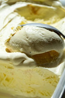 Vanilyalı dondurma kaşıkla konteynırdan çıkarıldı.