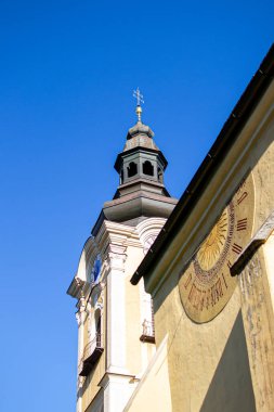 Kilisenin duvarında ve kulesinde modern ve eski saatler.