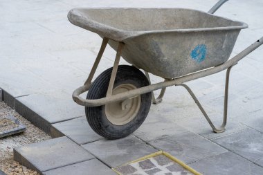 İnşaat alanında mavi bir el arabası ve çimento..