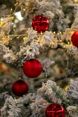 Cam toplar ve çelenklerle süslenmiş Noel ağacı.