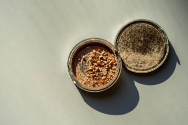 Kırık palet ve beyaz bir masada bronzlaştırıcı. Dekoratif kozmetik.
