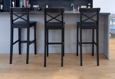 Mutfak adasının yakınındaki üç uzun siyah tahta bar taburesinin manzarası..