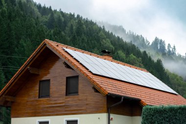 Konut binasının çatısına kurulmuş güneş panellerinin görüntüsü.