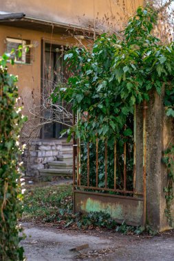 Eski paslı bir kapısı olan terk edilmiş bir evin manzarası..