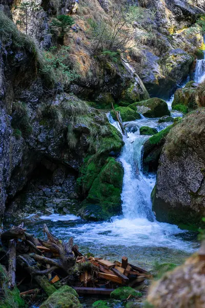 Güneşli bir günde Alp dağları arasındaki bir dağ nehrinin çağlayanı..