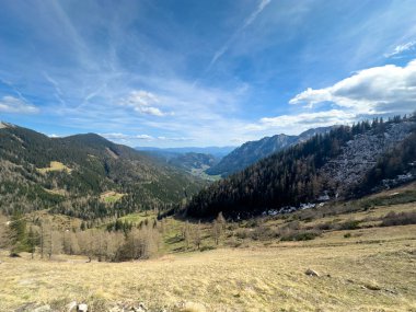 Dağlardan birinin tepesinden baharda mavi gökyüzüne bakan bir dağ vadisi manzarası