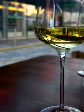 Restoran masasında duran beyaz şarapla dolu bir bardağın görüntüsü..