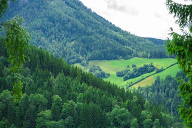 Alp Dağları 'nın tepesinden gökyüzünün arka planına doğru kalın bulutlar içinde vadinin görüntüsü
