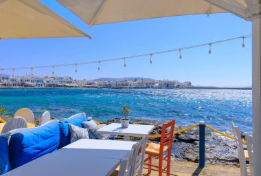 Yunanistan 'daki Mykonos kasabasının silüeti: deniz kıyısındaki tipik bir restorandan liman manzarası.