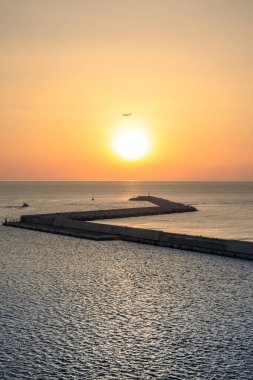 Gün batımında Bari Limanı: Bir uçakla rıhtım ve güneş..