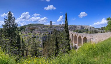 Roma zamanından kalma Aqueduct Köprüsü ve İtalya 'nın güneyindeki Puglia kasabasındaki Gravina' da kayalık evler vadisinin manzarası..