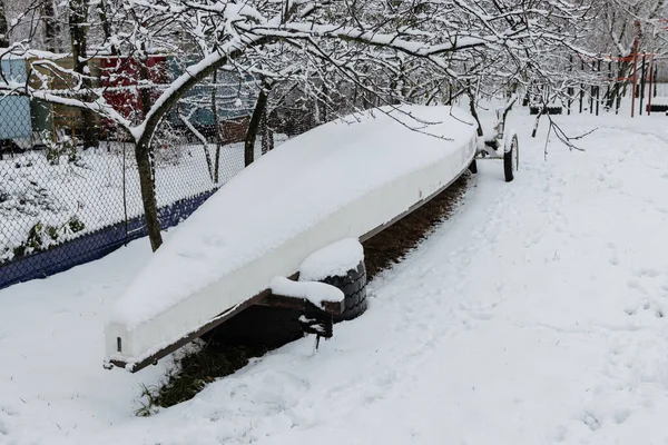 Karla kaplı çok koltuklu kano. Kışın kano ve kano deposu.