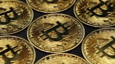 Altın bitcoin paraların yakın plan çekimleri siyah arka planda yavaşça dönüyor. Dijital para birimleri BTC şifreleme para birimi. Engelleme teknolojisi, bitcoin madenciliği. Dönen bitcoinlerin makro görüntüsü.