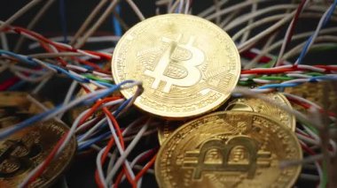 Altın bitcoin sikkelerin yakın planında kablolar yavaşça dönüyor. BTC şifreleme dijital para birimi teknolojisi.