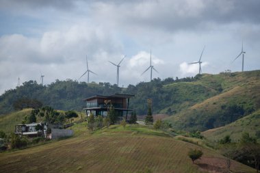 Yenilenebilir elektrik üretimi için bir grup yel değirmeni. Kırsal bölgelerdeki dağlarda rüzgar türbinleri çiftliği. Khao Kho bölgesindeki temiz enerji sistemi, Phetchabun, Tayland, Güneydoğu Asya.