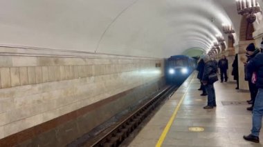 Kyiv, Ukraine - Passengers wait for the arrival of a metro train. A blue subway train with people inside arrives at the station. High quality 4k footage