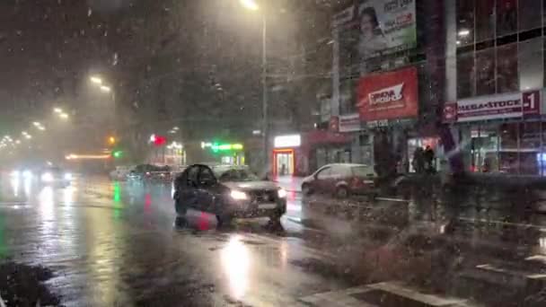 乌克兰基辅 2023年3月 雪灾期间城市街道上的交通 城市在暴风雪中 晚上有车和人 高质量的4K镜头 — 图库视频影像
