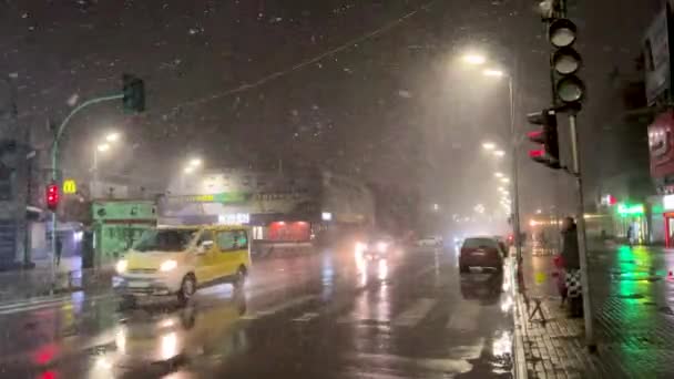 乌克兰基辅 2023年3月 冬季傍晚的一场雪中 人们在城市的人行横道上穿过马路 城市在暴风雪中 晚上有车和人 高质量4K — 图库视频影像