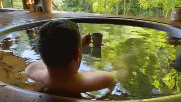 Чоловік Відпочиває Гарячій Ванні Чай Чашки Насолоджуючись Сонячним Світлом Природою — стокове відео
