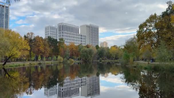 10月の市立公園の美しい秋の風景 多彩な木々や多階建ての建物が湖の穏やかな水に映し出されています 高品質の4K映像 — ストック動画