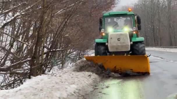 运雪卡车把雪从公路上移开 在多雾 多雪的天气里 绿色的小雪地推土机正在清扫路上的雪 高质量的4K镜头 — 图库视频影像