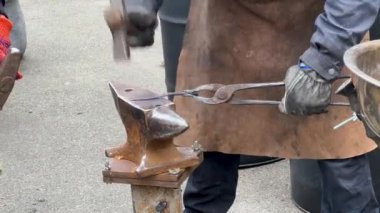 Demirci, metal dövmek için çekiç kullanır. Erkek demirci, örse çekiçle sıcak metal döver. Yüksek kalite 4k görüntü