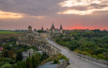 Kamianets-Podilskyi Ortaçağ Şatosu 'nun günbatımı Panoraması. Gün batımında Smotrych Nehri 'nin kanyonunda kayalık bir yarımadada güzel, ünlü bir kale, gün batımında şehir manzarası..