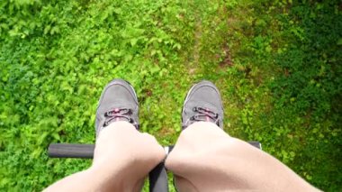 Spor ayakkabılı kadın bacakları yeşil sulu çimenlerin üzerinde süzülüyor. Yüksek kalite 4k görüntü