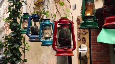 Bir sıra klasik, kırsal, çok renkli gazyağı lambaları arka arkaya asılır ve rüzgarda sallanarak rahat bir atmosfer yaratır. Eski model benzin lambası. Yüksek kalite 4k görüntü