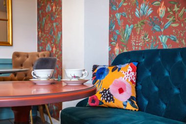 Stylish relaxation Nook: Vintage Teacups ve Modern Colful Minderler. Klasik Charm Modern Tasarımla Tanışıyor: Çay fincanları ve Tufted Mobilya. Yüksek kalite fotoğraf