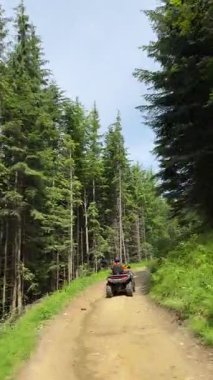 ATV bisikletli bir adam dağda. Doğada güzel bir geçmişi olan bisikletli bir turist. İnsanlar, eğlence ve tatil konsepti. Dikey video. Yüksek kaliteli FullHD görüntüler