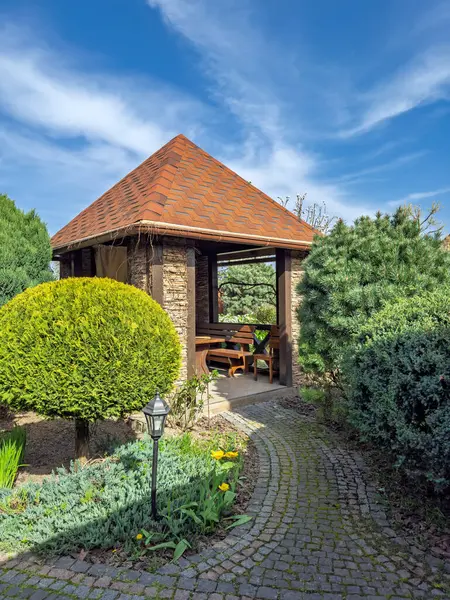 Parlak Bahar Gününde Güneşli Bahçe Bahçesi Çardakları. Evergreens 'le çevrili ahşap bahçe köşkü. Bahçeye Davet Bahçesi Oturma Alanı. Yüksek