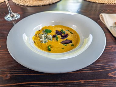 Mavi Peynirli gurme mısır çorbası, kavrulmuş pancar kökü ve beyaz kâsede bitkiler. Mavi Peynirli gevrek ve pancar garnitürlü kremalı mısır çorbası. Yüksek kalite fotoğraf