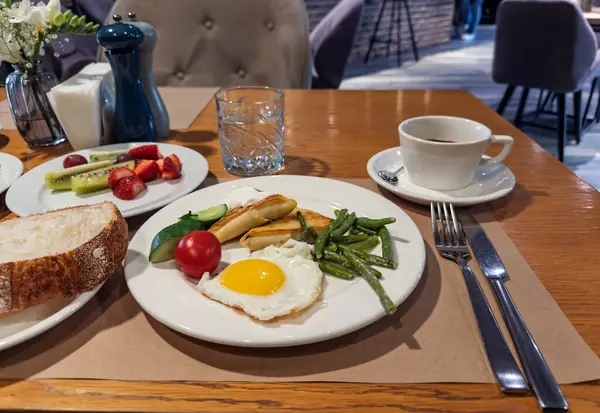 Modern Kafede Sağlıklı Kahvaltı: Kızarmış Yumurta, Peynir, Yeşil Fasulye ve Taze Meyve. Hotel Style Breakfast. Dengeli Sabah Yemeği. Yüksek kalite fotoğraf