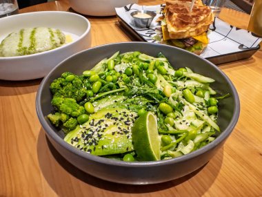Vibrant Green Salad Bowl: Avocado, Edamame, Broccoli, salatalık, limon. Avocado, Edamame ve Susam Tohumu ile sağlıklı ve taze sebze salatası. Restoran Tarzı Yeşil Güç Bowl. Yüksek kalite fotoğraf