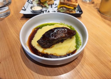 Yavaş pişirilmiş kremalı biftek, patates püresi ve Herb yağı karışımı. Gurme tabağı: Patates püresi, Dark Jus ve Pesto.Hearty Restaurant Menü ile ağır ateşte pişirilmiş et. Yüksek kalite fotoğraf