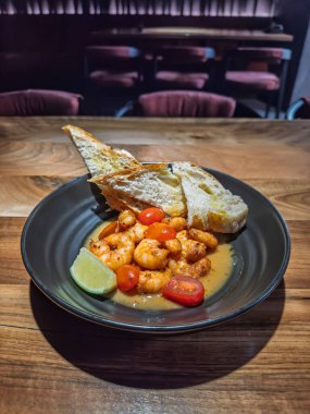 Toasted Baguette Dilimleri ve Limonlu Akdeniz usulü Karides Scampi. Lezzetli Deniz Ürünleri Başlangıcı: Domates, limon ve sarımsaklı karides. Yüksek kalite fotoğraf