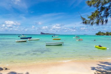 Bereketli bitki örtüsü ve Mire Adası manzaralı uzak Coin de Mire Adası manzarasıyla çevrili saydam zümrüt su üzerinde yüzen küçük ahşap botları olan huzurlu bir lagün. Idyllic tropikal deniz manzarası. Yüksek